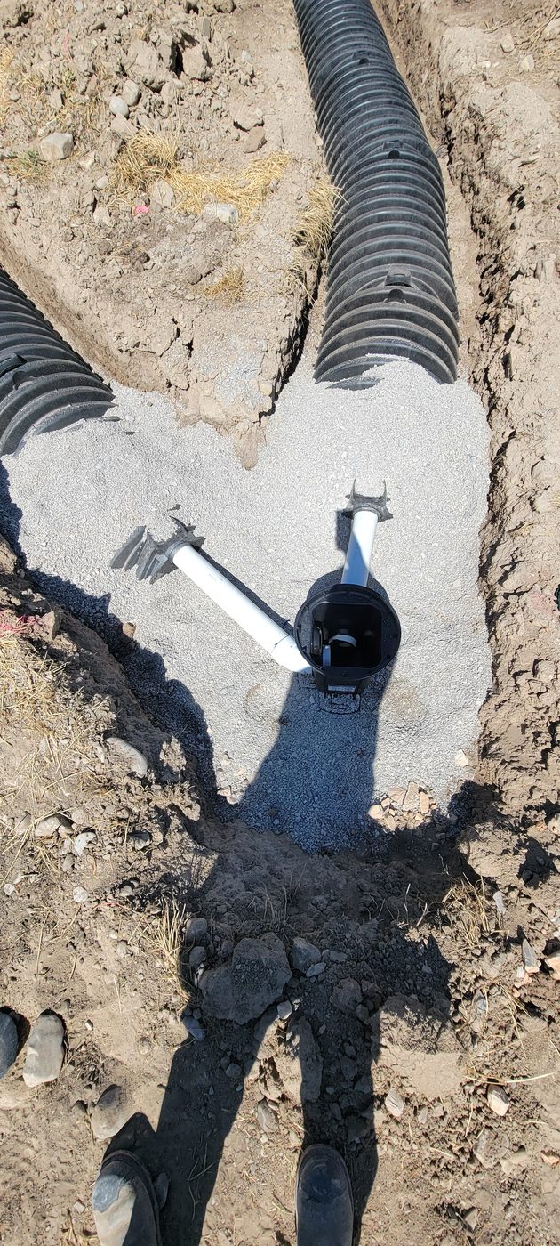 Distribution box with outlet lines feeding chambered drain field trenches, Utah septic installation